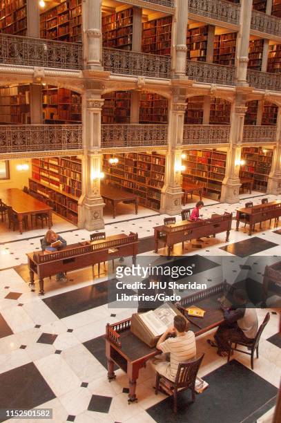 Bird's-eye view of patrons looking at books on the ground floor of the George Peabody Library at the Johns Hopkins University, Baltimore, Maryland,...