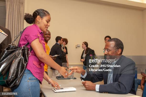 Profile shot of neurosurgeon Ben Carson, smiling as he meets an attendee during a Milton S Eisenhower Symposium at the Johns Hopkins University,...