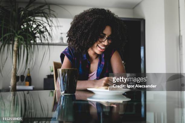 teen girl snacking and reading messages - moving down to seated position stock pictures, royalty-free photos & images