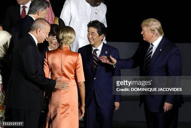 President Donald Trump greets Turkey's president Recep Tayyip Erdogan next to Japan's Prime Minister Shinzo Abe and his wife Akie as they pose for a...