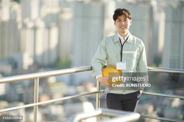 portrait of engineer standing on urban rooftop - 工事　日本人 ストックフォトと画像