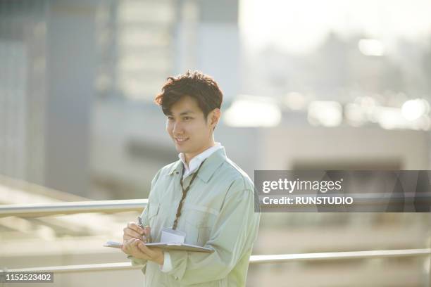 engineer writing on clipboard on rooftop - roof inspector stock pictures, royalty-free photos & images