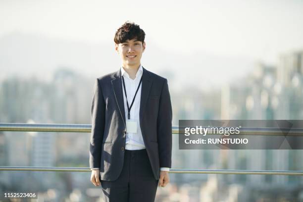 portrait of businessman standing on rooftop - 会社員　日本人 ストックフォトと画像