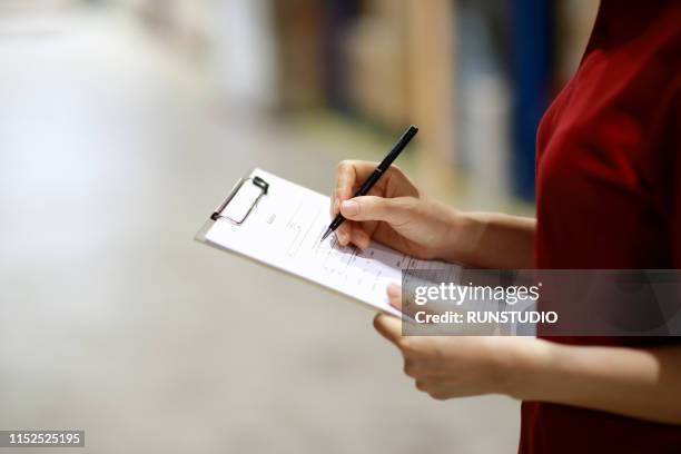 warehouse worker taking inventory in logistics warehouse - clipboard stockfoto's en -beelden