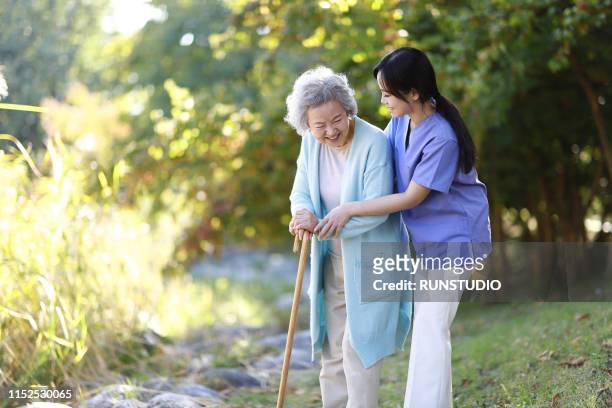 nurse helping senior woman with cane - grandma cane stock pictures, royalty-free photos & images