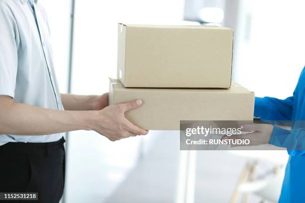 man receiving package from delivery man - consegna a domicilio foto e immagini stock