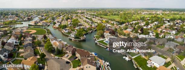 the wealth residential district in oceanside, queens, new york city, with houses with pools on backyards and piers with boats along the channels. extra-large high-resolution stitched aerial panorama. - hempstead stock pictures, royalty-free photos & images