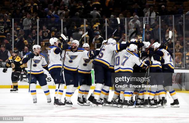 Carl Gunnarsson of the St. Louis Blues is congratulated by his teammates after scoring the game-winning goal during the first overtime period to...