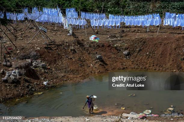 Women carry water for domestic purpose from nearby pond of dry bed of Puzhal lake on June 28, 2019 in the outskirts of Chennai, India. All the four...
