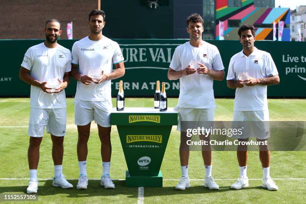 Juan Sebastian Cabal and Robert Farah of Columbia and Argentina pair Maximo Gonzalez and Horacio Zeballos pose with the winners and losers trophy...