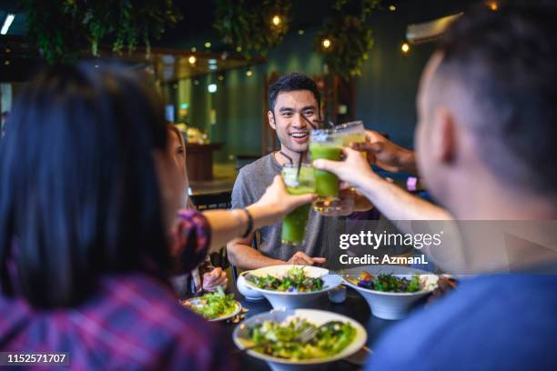 group of friends toasting their good health in a paleo cafe - paleo diet stock pictures, royalty-free photos & images