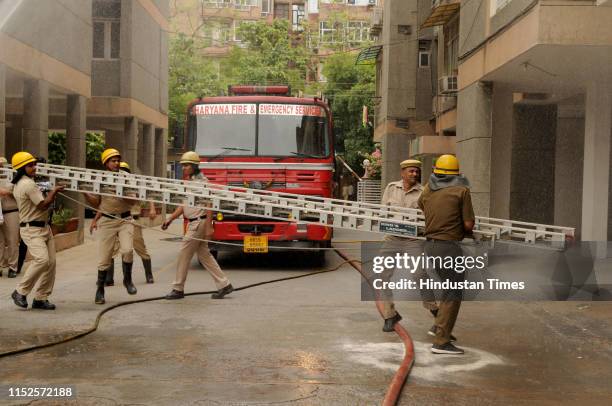 Firefighters during the mock rescue operation exercise, at Hope Apartment, Sector 15 part-2 on June 28, 2019 in Gurugram, India. A mock scenario of...