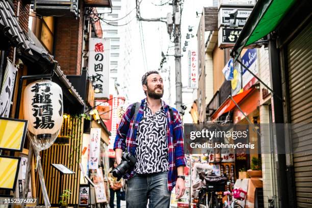 low angle view of tourist walking through urban street - holiday in tokyo stock pictures, royalty-free photos & images