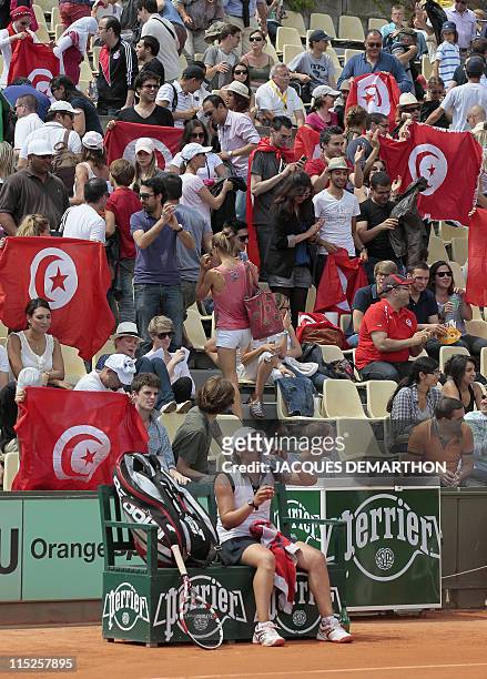 Tunisian supporters wave national flags as Tunisia's Ons Jabeur plays with Puerto Rico's Monica Puig during their Girls's Singles final match in the...