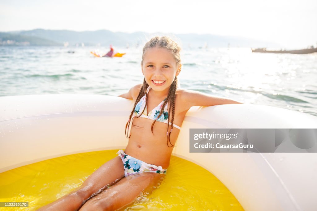 Cheerful Young Girl Relaxing On Inflatable Pool Raft In The Sea High