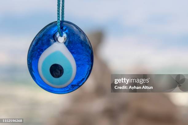 evil eye in wish tree behind uchisar castle in cappadocia, nevsehir, central anatolia of turkey - talisman stock pictures, royalty-free photos & images