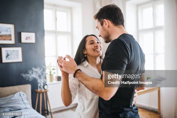 affectionate young couple in love dancing at home, having fun. - coniugi foto e immagini stock