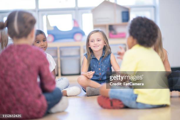 bambini che chiacchierano a scuola - bambini seduti in cerchio foto e immagini stock