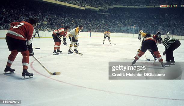 Ken Hodge of the Boston Bruins, Joe Watson and Tom Bladon of the Philadelphia Flyers wait for the face off during their game circa 1974 at the Boston...