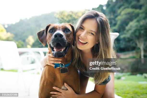 schöne frau spielt mit ihrem hund im freien im hinterhof - rhodesian ridgeback stock-fotos und bilder
