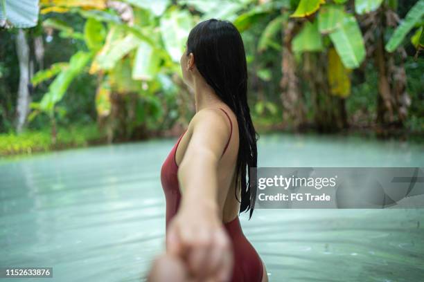 girlfriend holding boyfriend hands exploring and discovery fervedouro in tocantins, brazil - tocantins stock pictures, royalty-free photos & images