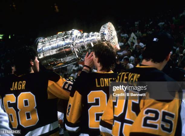 Jaromir Jagr of the Pittsburgh Penguins gets handed the Stanley Cup as teammate Troy Loney waits his turn after Game 4 of the 1992 Stanley Cup Finals...