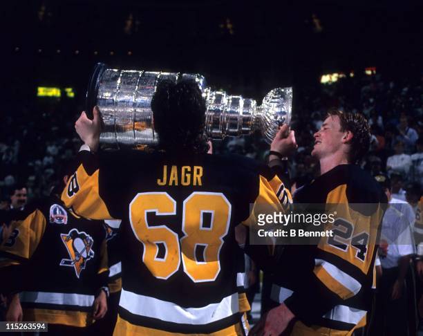 Jaromir Jagr of the Pittsburgh Penguins kisses the Stanley Cup as teammate Troy Loney waits his turn after Game 4 of the 1992 Stanley Cup Finals...