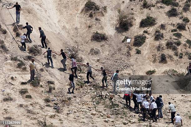 Pro-Palestinian demonstrator is helped after being shot at by Israeli troops, as seen from the Druze village of Majdal Shams, on June 5, 2011 in...