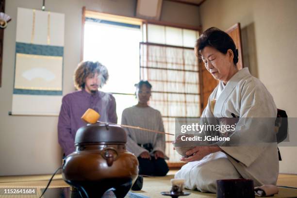 japanese tea master washing a bowl ahead of making matcha tea as part of a ceremony - afro man washing stock pictures, royalty-free photos & images