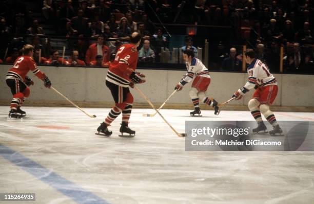 Brad Park and Jean Ratelle of the New York Rangers skate up the ice with the puck as Bill White and Pat Stapleton of the Chicago Blackhawks defend...