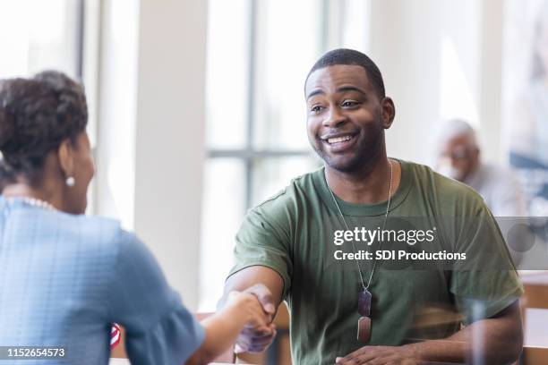 banker and soldier shake hands to close deal on mortgage - army soldier smiling stock pictures, royalty-free photos & images