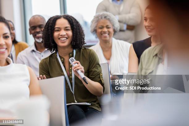 afroamerikanerin lacht mit publikum - podiumsdiskussion stock-fotos und bilder