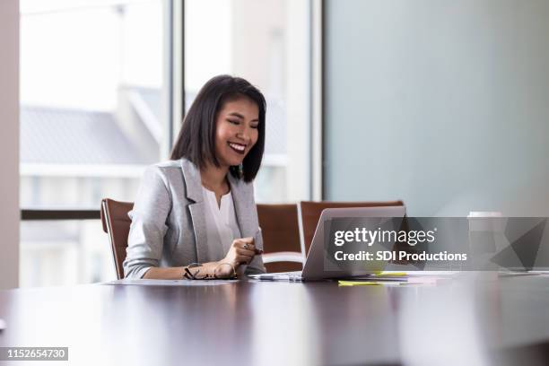 cheerful young businesswoman video chats with colleague - female financial advisor stock pictures, royalty-free photos & images