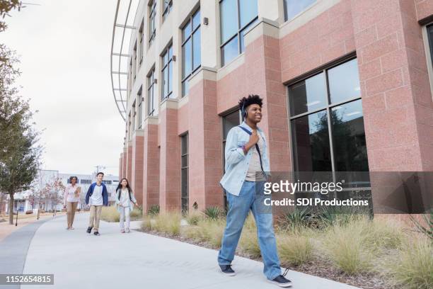 teenage boy walking to school - public school building stock pictures, royalty-free photos & images