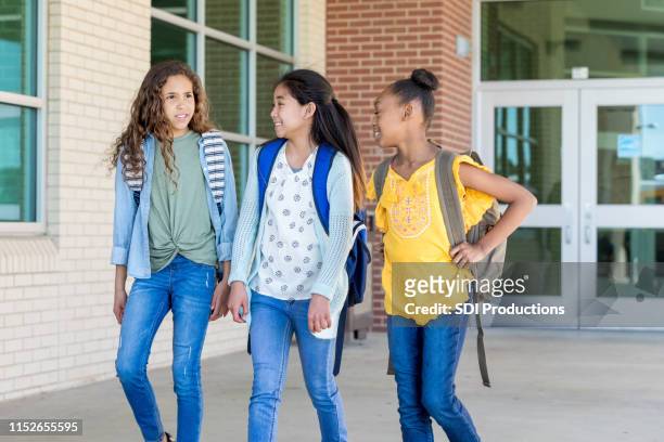 three school friends walk and talk together - last day of school stock pictures, royalty-free photos & images