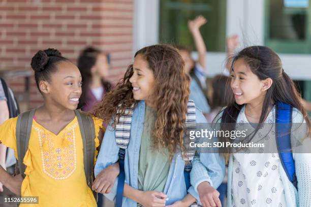 le ragazze vanno a casa dal braccio della scuola a braccetto - educazione secondaria di scuola media foto e immagini stock
