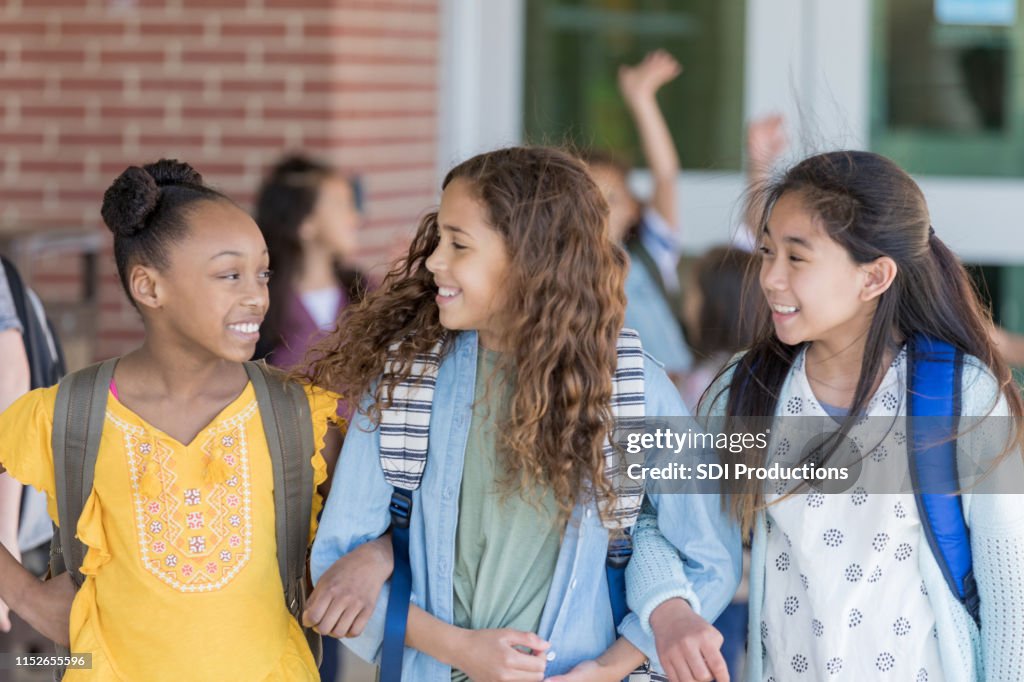 Girls walk home from school arm in arm