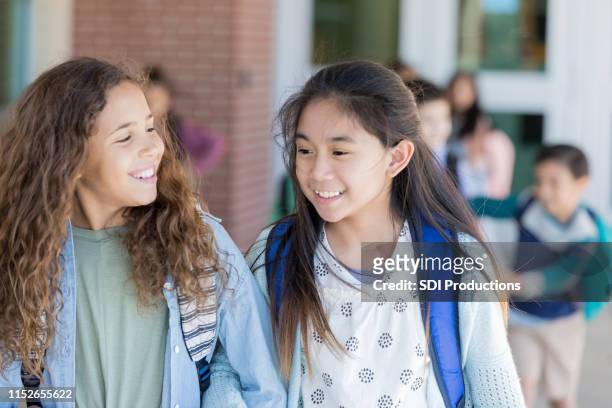 two best friends walk home arm in arm - last day of school stock pictures, royalty-free photos & images
