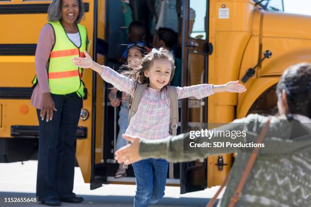 schoolgirl runs from school bus to hug mother - picking up kids stock pictures, royalty-free photos & images