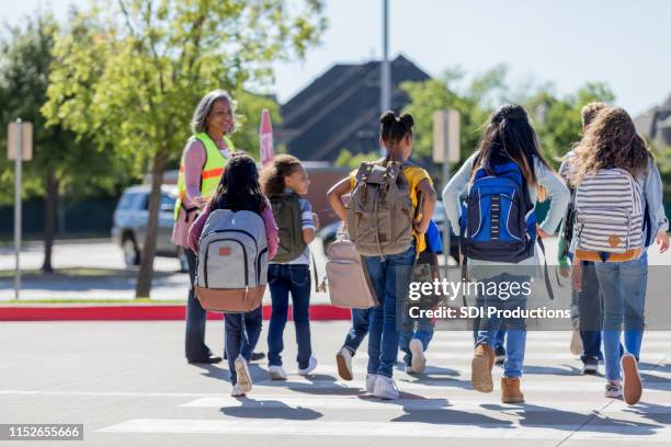 schulkinder überqueren auf dem heimweg die straße - cross road children stock-fotos und bilder