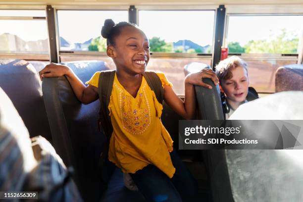 happy schoolgirl smiles a toothy smile on bus - school bus kids stock pictures, royalty-free photos & images