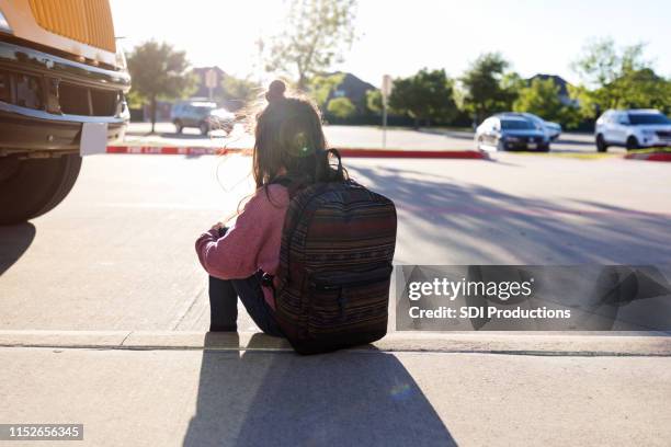 anonymous schoolgirl sits on curb by herself - child waiting stock pictures, royalty-free photos & images