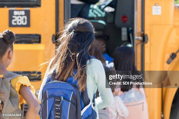 kinder steigen in einen schulbus in einer linie - obscured face stock-fotos und bilder