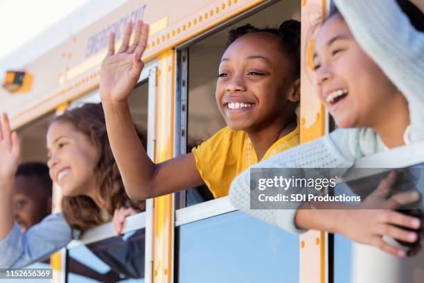 school children wave from school bus - hello future are you there stock pictures, royalty-free photos & images