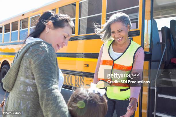 busfahrer und mutter lächeln auf schulmädchen - smile woman child stock-fotos und bilder