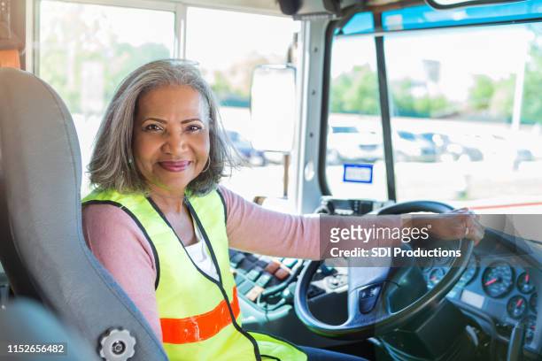 女性のバスドライバーは自信を持ってカメラを見て - バス運転手 ストックフォトと画像