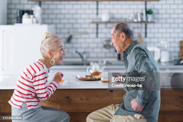 coppia senior che prende il tè in cucina - the japanese wife foto e immagini stock