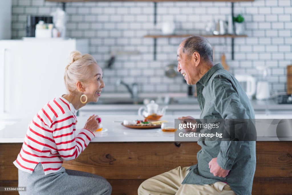 Senior couple having tea in kitchen