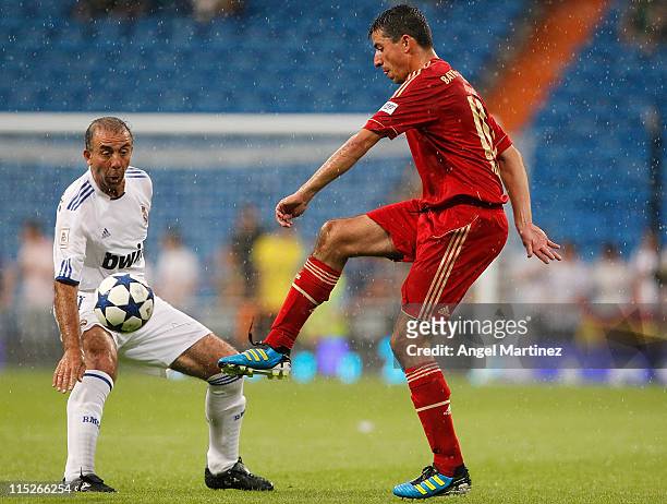 Roy Makaay of Bayern Muenchen is challenged by Rafael Garcia Cortes of Real Madrid during the Corazon Classic Match between Allstars Real Madrid and...