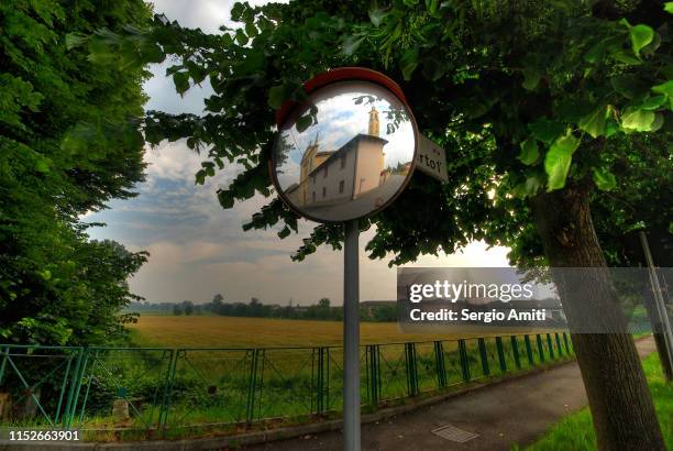 san bernardino church reflected in a road mirror - konvex stock-fotos und bilder